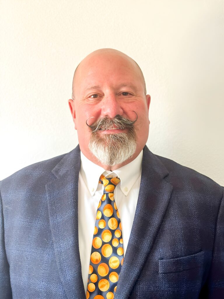 Bald man in suit and colorful tie